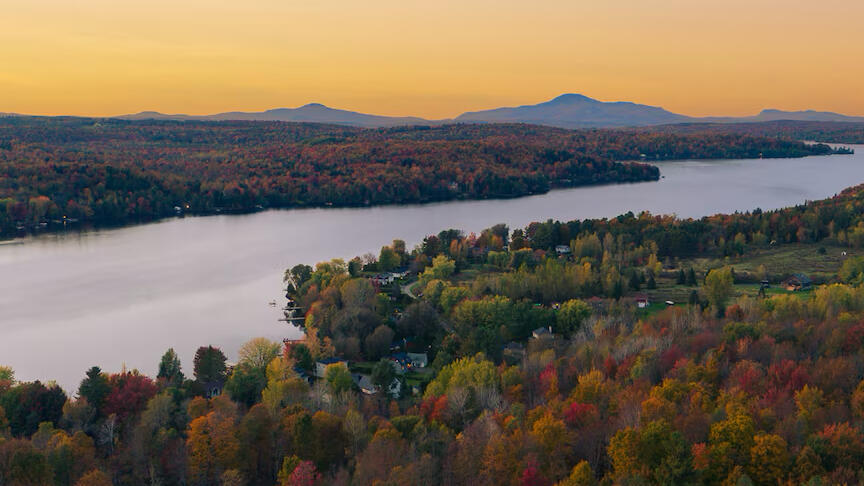 Panoramic view of Lake Lovering in Magog, Eastern Townships, at sunset. Aerial view of Lake Lovering in Magog, Eastern Townships, with mountains and fall foliage.